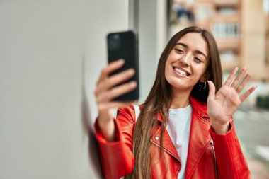 Genç İspanyol kadın şehirde akıllı telefon kullanarak video görüşmesi yapıyor..