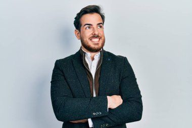 Kollarını kavuşturmuş, gülümseyen ve kafasını çeviren sakallı yakışıklı beyaz adam.. 