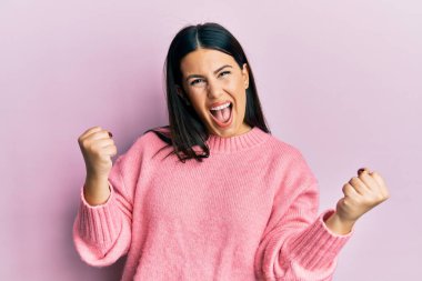 Güzel esmer kadın, sıradan bir kazak giyiyor gururla bağırıyor, zaferi kutluyor ve kollarını kaldırarak çok heyecanlanıyor. 