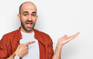 Gündelik kıyafetler giyen genç İspanyol adam kameraya hayret ediyor ve gülümsüyor.. 