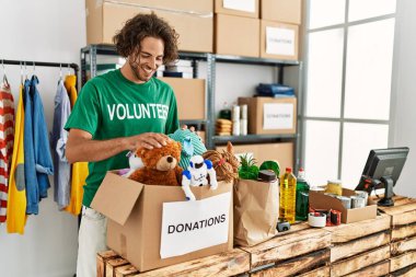 Yardım merkezinde çalışırken gülümseyen Latin asıllı gönüllü adam..
