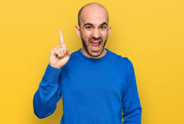 Gündelik kıyafetler giyen genç İspanyol adam başarılı bir fikirle işaret ediyor. Heyecanlı ve mutlu. Bir numara.. 