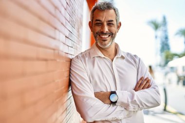 Orta yaşlı, kır saçlı, mutlu gülümseyen bir adam..