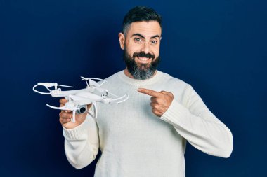 İHA 'yı tutan genç İspanyol adam gülümsüyor. 