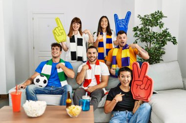 bir grup insan evde maç izliyor.