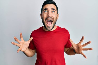 Gündelik kıyafetler giyen genç İspanyol adam deli gibi bağırıyor ve agresif bir ifade ve kollarla bağırıyor. hüsran kavramı. 