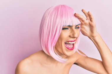 Pembe peruk takan genç adam çok mutlu ve gülümsüyor. arama kavramı. 