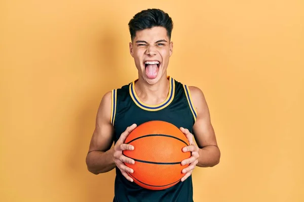 Jeune Homme Hispanique Tenant Ballon Basket Ball Langue Collante Heureux — Photo