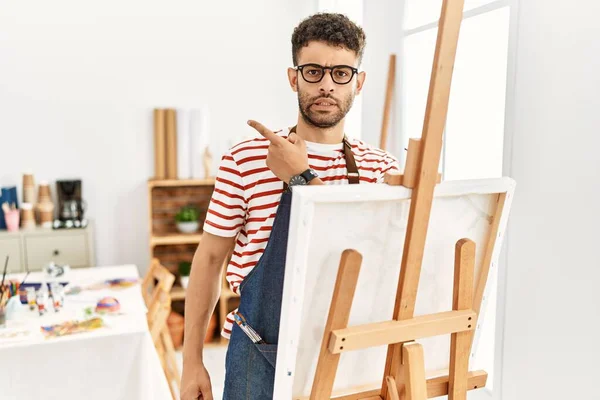 Hombre Joven Árabe Estudio Arte Señalando Lado Preocupado Nervioso Con —  Fotos de Stock