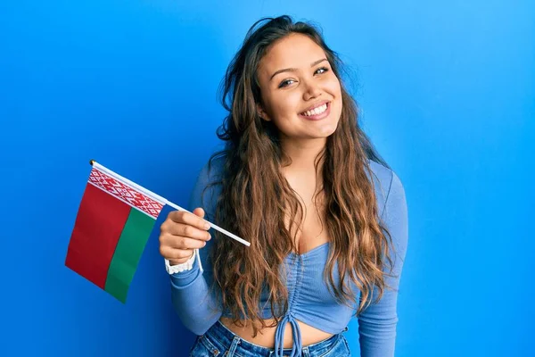 Młoda Latynoska Dziewczyna Trzyma Flagę Belarus Patrząc Pozytywnie Szczęśliwy Stojąc — Zdjęcie stockowe