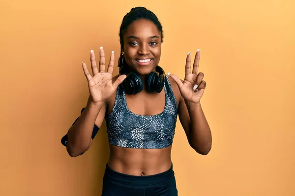 Mujer Afroamericana Con Cabello Trenzado Usando Ropa Deportiva Brazalete Mostrando —  Fotos de Stock