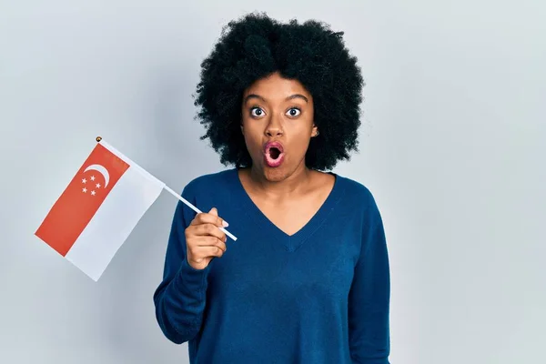 Young African American Woman Holding Singapore Flag Scared Amazed Open — 스톡 사진