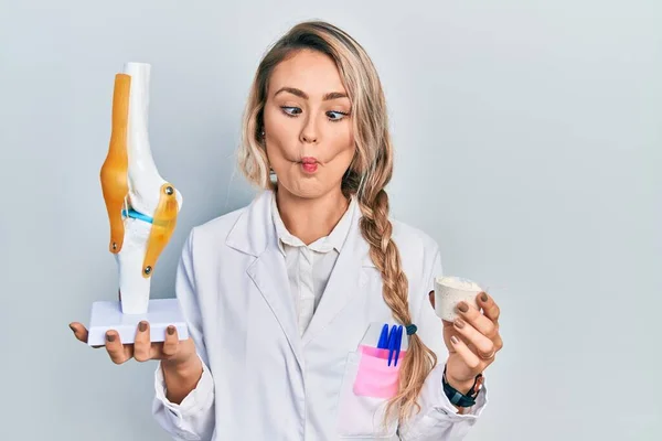Krásná Mladá Blondýnka Lékař Žena Drží Anatomický Model Kolenního Kloubu — Stock fotografie