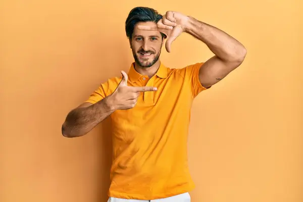 Joven Hombre Hispano Vistiendo Camiseta Amarilla Casual Sonriendo Haciendo Marco — Foto de Stock
