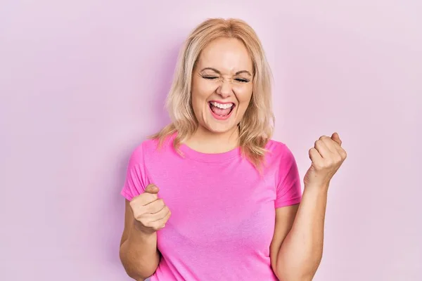 Jonge Blonde Vrouw Draagt Casual Roze Shirt Vieren Verrast Verbaasd — Stockfoto