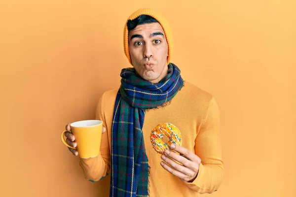 Hombre Hispano Guapo Comiendo Donut Bebiendo Café Mirando Cámara Soplando — Foto de Stock