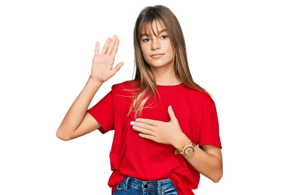 ティーンCaucasian女の子身に着けていますカジュアル赤Tシャツ身に着けています手で胸とオープン手のひら 忠誠の誓いを作ります — ストック写真