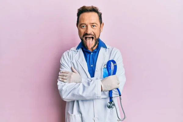 Middle Age Man Wearing Doctor Uniform Sticking Tongue Out Happy — Stock Photo, Image