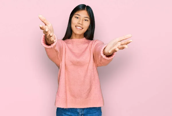美丽的年轻亚洲女人穿着休闲地冬季毛衣 看着相机 张开双臂拥抱 欢快的表达拥抱幸福 — 图库照片