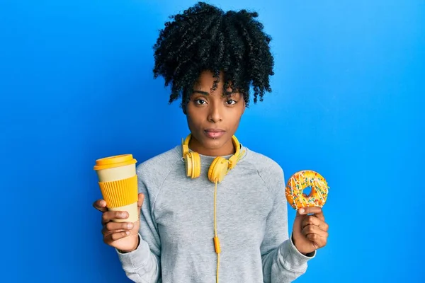 Africká Američanka Afro Vlasy Jíst Koblihu Pít Kávu Uvolněně Vážným — Stock fotografie