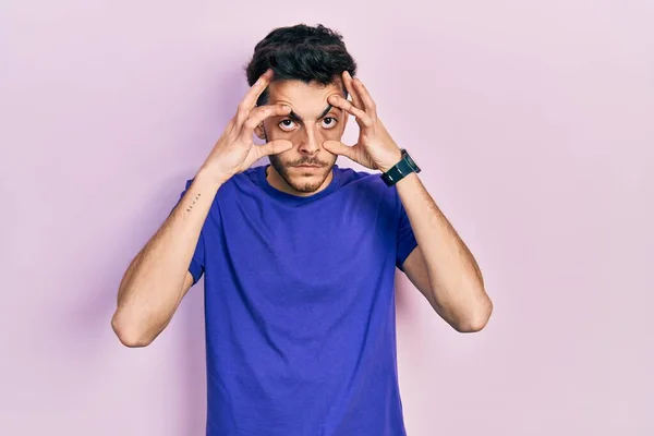 Gündelik Tişört Giyen Genç Spanyol Adam Parmaklarıyla Gözlerini Açmaya Çalışıyor — Stok fotoğraf