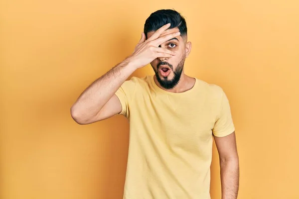 Hombre Guapo Con Barba Vistiendo Camiseta Amarilla Casual Asomándose Shock —  Fotos de Stock