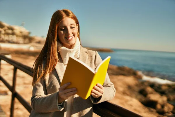 Νεαρή Κοκκινομάλλα Χαμογελά Χαρούμενο Βιβλίο Ανάγνωσης Στην Παραλία — Φωτογραφία Αρχείου