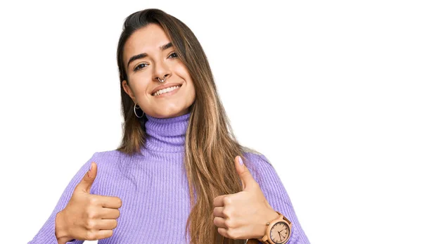 若いヒスパニック系の女性が手で積極的なジェスチャーを行うカジュアルな服の成功のサインを着て 親指を笑顔と幸せ 陽気な表情と勝者のジェスチャー — ストック写真