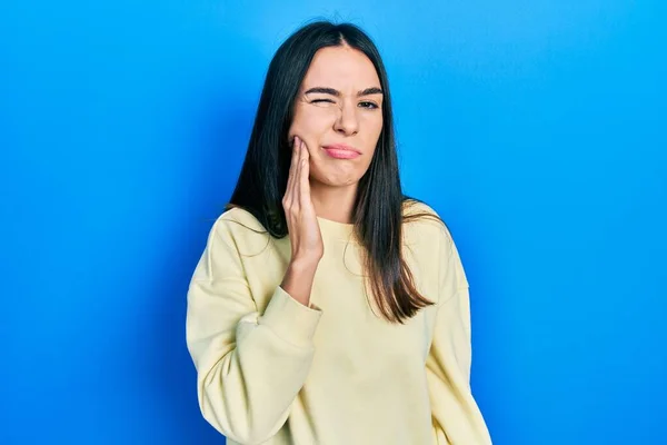 歯痛や歯の病気のために痛みを伴う表現で手に触れるカジュアルなスウェットシャツを身に着けている若いブルネットの女性 歯科医 — ストック写真