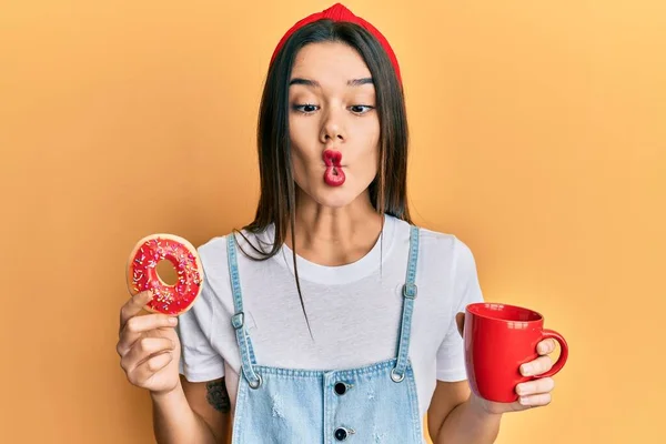 Joven Chica Hispana Comiendo Donut Tomando Café Haciendo Cara Pescado — Foto de Stock