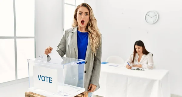 年轻的金发女郎投票时把信封放进投票箱 吓得张大了嘴 惊慌失措的样子 — 图库照片