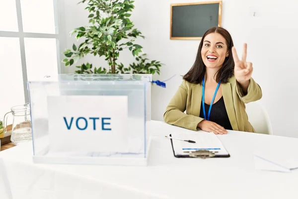 Joven Morena Sentada Mesa Electoral Con Boleta Electoral Mostrando Señalando —  Fotos de Stock