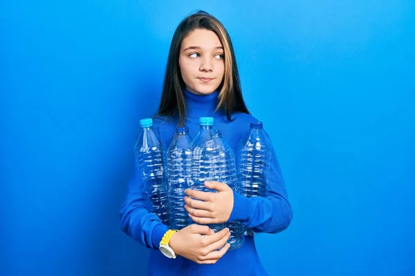 Genç Esmer Kız Elinde Plastik Şişelerle Gülümsüyor Yan Tarafa Bakıyor — Stok fotoğraf