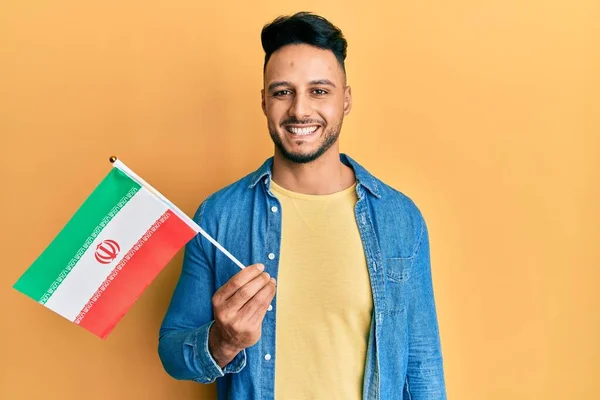 Mladý Arabský Muž Držící Íránskou Vlajku Vypadá Pozitivně Šťastně Stojící — Stock fotografie