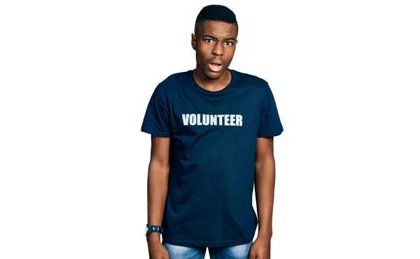 Young African American Man Wearing Volunteer Shirt Shock Face Looking — Stock Photo, Image