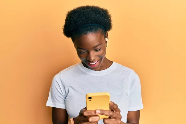Νεαρή Αφροαμερικανή Που Χρησιμοποιεί Smartphone Και Ακουστικά Χαμογελώντας Και Γελώντας — Φωτογραφία Αρχείου