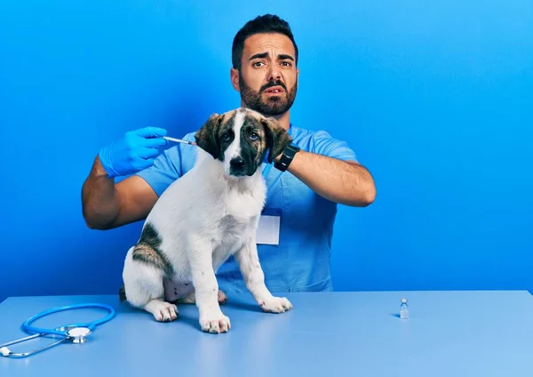 Красивый Латиноамериканец Ветеринар Бородой Вводит Вакцину Щенячьей Собаке Невежественное Запутанное — стоковое фото