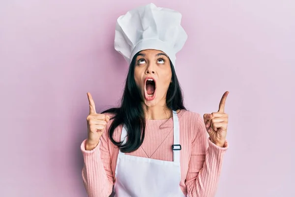 Ung Latinamerikansk Kvinna Bär Bagare Uniform Och Kock Hatt Förvånad — Stockfoto