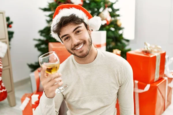 Ung Latinamerikansk Man Ler Glad Bär Jul Hatt Dricka Champagne — Stockfoto