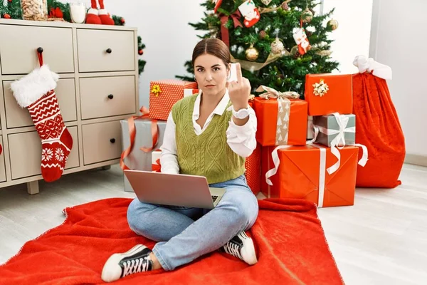 Young Beautiful Hispanic Woman Using Laptop Sitting Christmas Tree Showing — Φωτογραφία Αρχείου