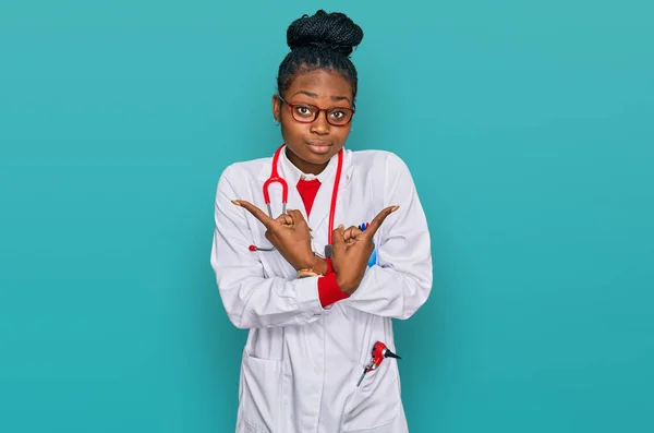 Mujer Afroamericana Joven Vistiendo Uniforme Médico Estetoscopio Apuntando Ambos Lados —  Fotos de Stock