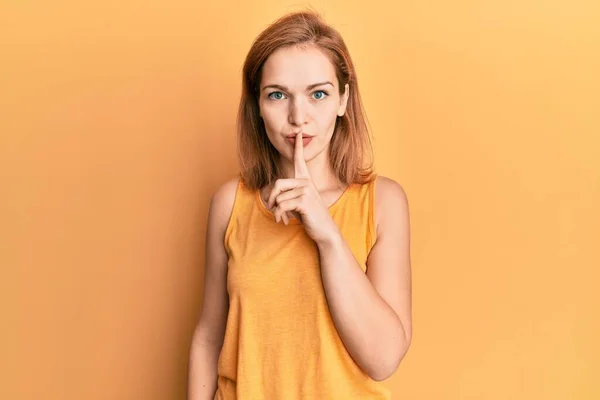 唇に指で静かになるように求める袖のないシャツを着た若い白人女性 沈黙と秘密の概念 — ストック写真