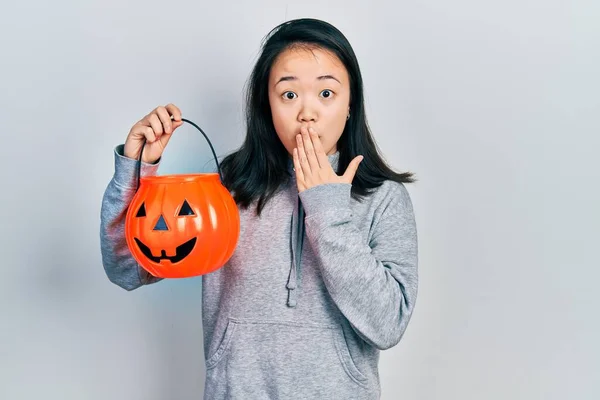 Menina Chinesa Jovem Segurando Cesta Abóbora Halloween Cobrindo Boca Com — Fotografia de Stock