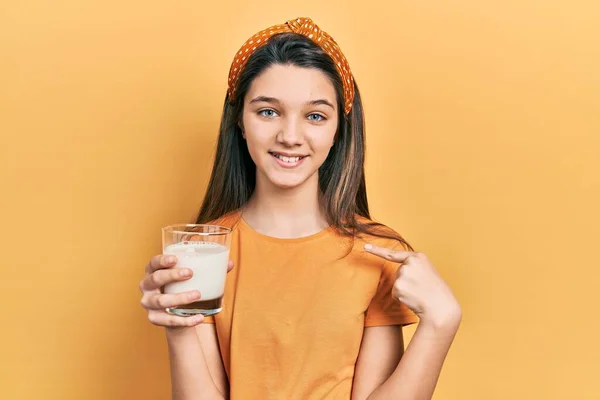 Νεαρή Καστανή Κοπέλα Πίνει Ένα Ποτήρι Γάλα Δείχνοντας Τον Εαυτό — Φωτογραφία Αρχείου