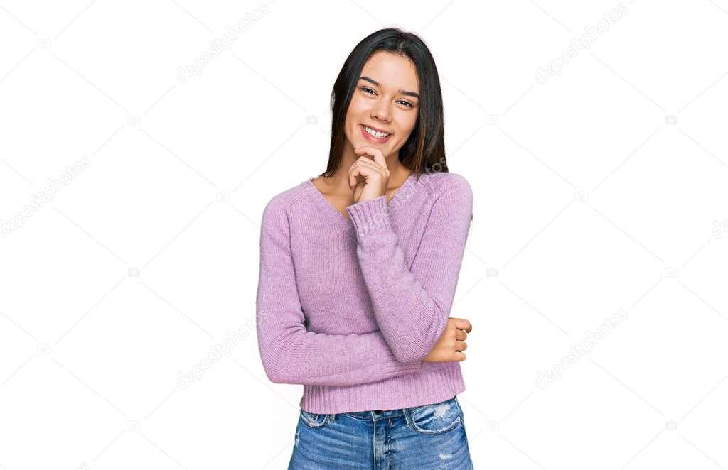 Young hispanic girl wearing casual clothes looking confident at the camera with smile with crossed arms and hand raised on chin. thinking positive. 