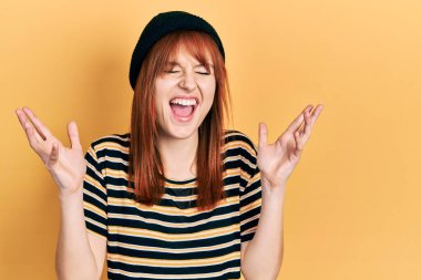 Kızıl saçlı, yün şapka takmış genç bir kadın başarı için deli ve çılgınlığı kutlarken kollarını kaldırmış ve gözlerini kapatmış heyecanlı çığlıklar atıyordu. Kazanan konsept 