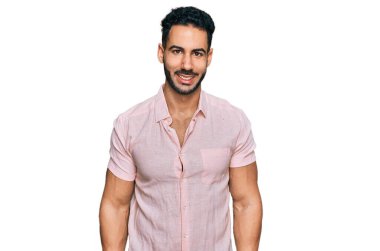 Sakallı, sıradan tişörtlü, mutlu ve havalı bir gülümsemesi olan İspanyol bir adam. şanslı kişi. 