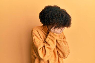Kışlık yün kazak giyen genç İspanyol kız. Ağlarken suratını ellerle kapatıyor. depresyon kavramı. 