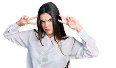 Genç esmer ergen barış jesti yapıyor şüpheci ve gergin gözlere yakın, sorun yüzünden somurtuyor. negatif kişi. 