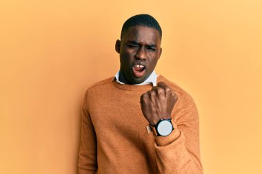 Genç, Afro-Amerikan bir adam, günlük kıyafetler giyiyor kızgın ve kızgın. Öfkeyle bağırırken yumruğunu kaldırıyor. öfke ve agresif konsept. 